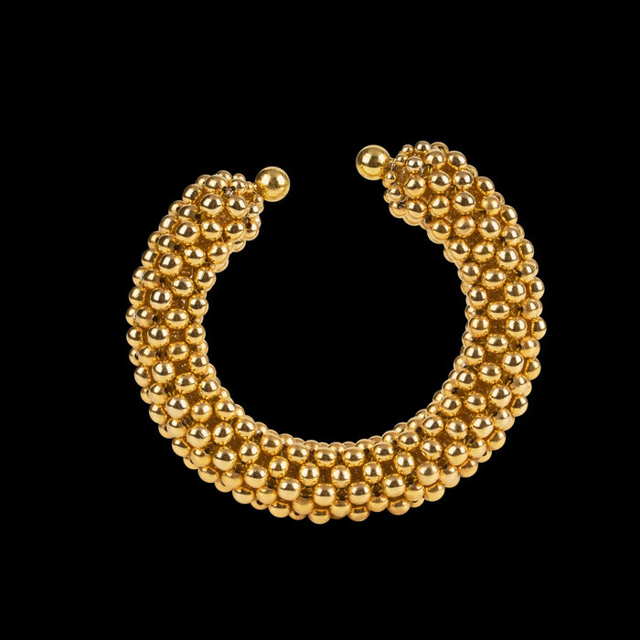 modular beaded wrist accessory in ivory, structured supple cuff with 22k gold wash polymer metal beads, ghost image front view