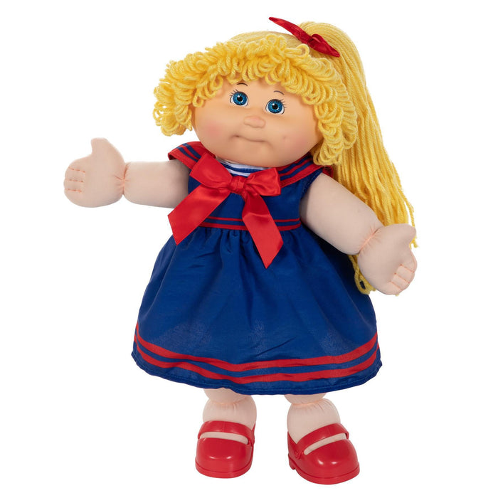 A 16-inch doll with blonde hair, blue eyes, wearing a navy blue and red sailor-style dress with a bow, and red shoes.