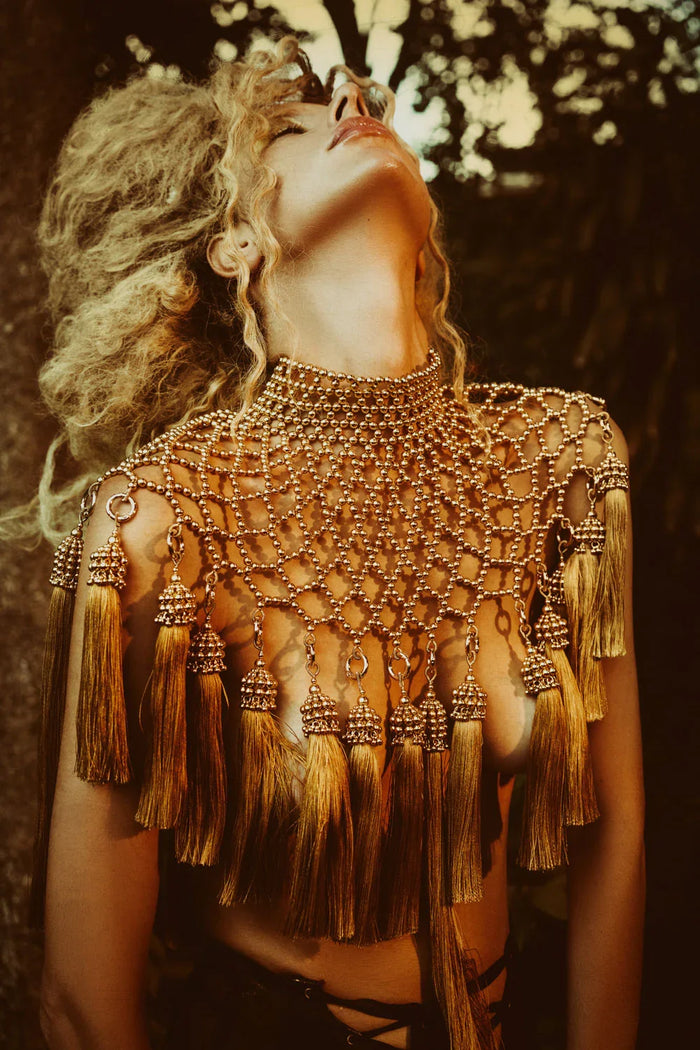 woman wearing freja modular cape with removable tassels by object and dawn