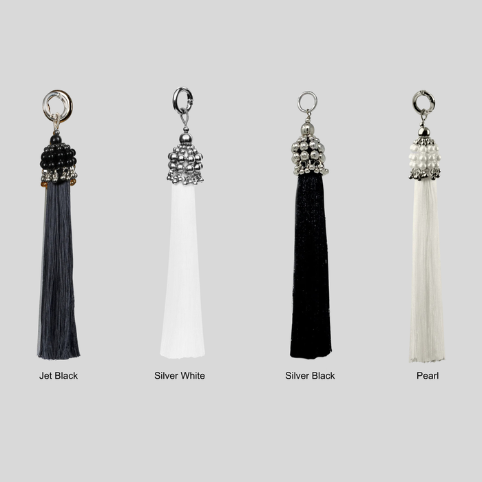 Set of four tassels in different colors with siver, pearl, and black crsytal beads on a grey background by Object&Dawn