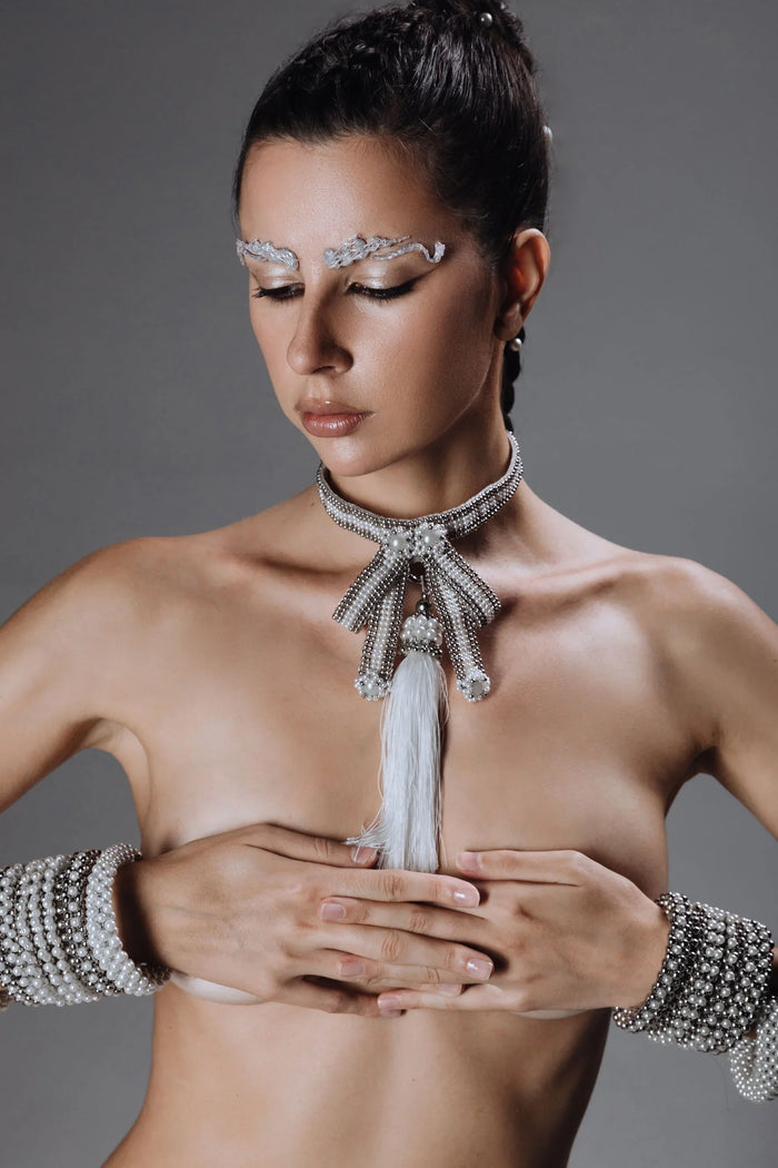 Beaded handcrafted polyester tassel by silver coated metal beads with systethic japanese pearl on grey background