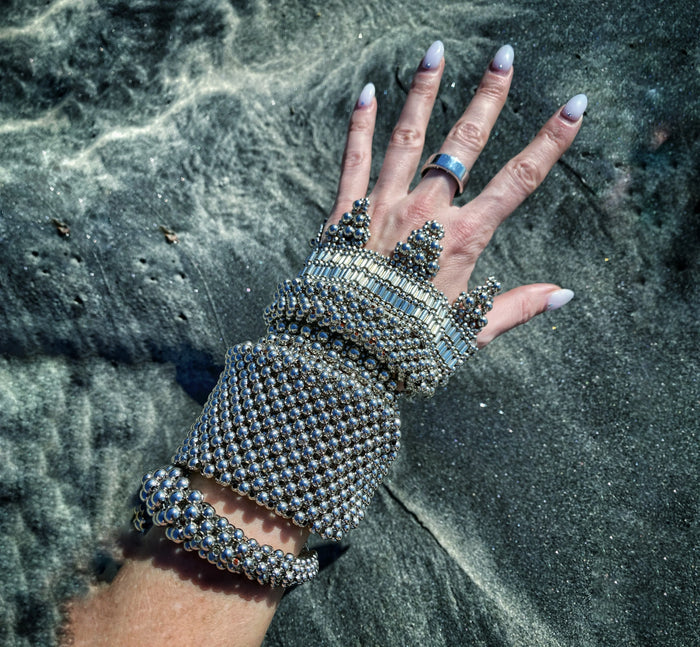 Beaded cuff from object and dawn worn by woman with sea background