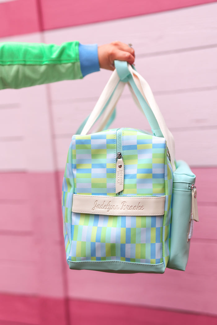Colorful checkered tote bag in blue and green, featuring a zip closure and leather logo patch.