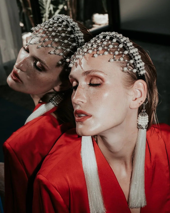 Woman wearing a red outfit with decorative freja headband against a mirror background