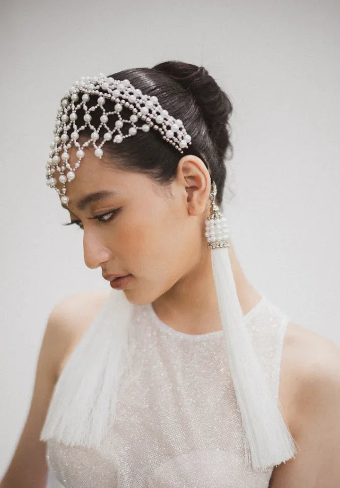 East asian bride wearing Freja Headband in Pearl with two white 11" tassels.