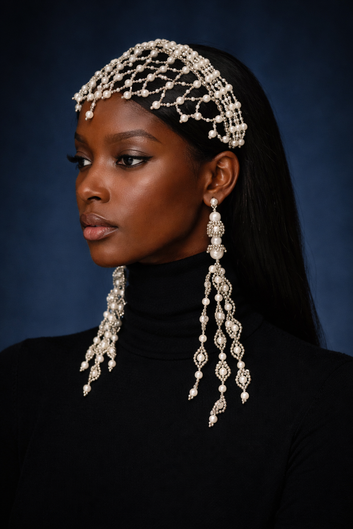 Woman wearing a decorative headband and earrings against a dark background