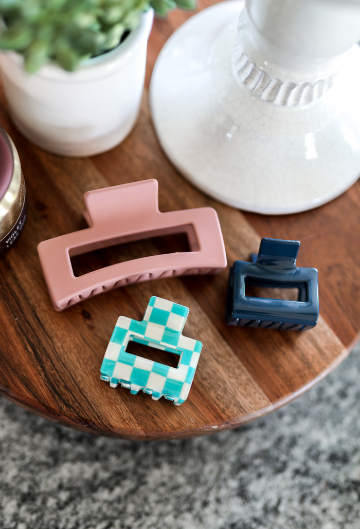 Set of three stylish hair clips in pink, blue checkered, and navy colors, made from durable plastic.