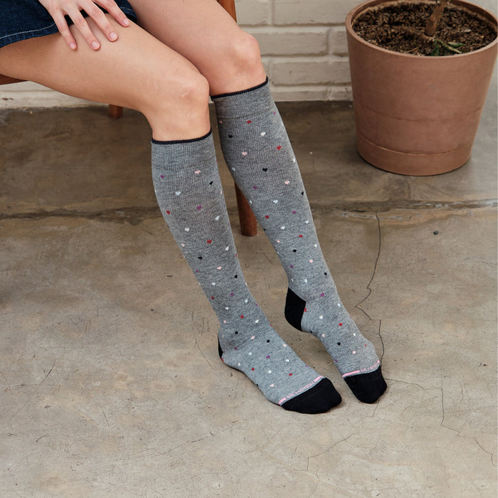 Knee-high gray compression socks with colorful heart patterns and black toe and heel accents.