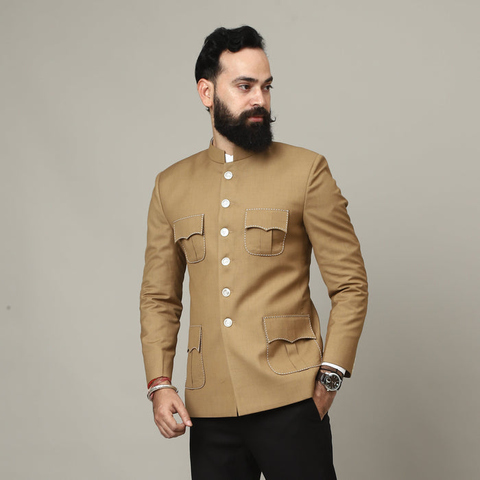 Man wearing a beige jacket and black pants against a plain background