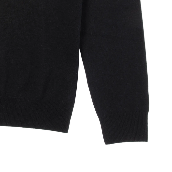 Close-up of a black sweater sleeve on a white background