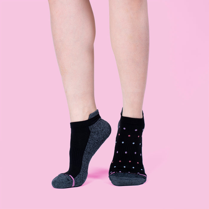 Ankle compression socks featuring a solid black design on one side and a polka dot pattern on the other, displayed against a