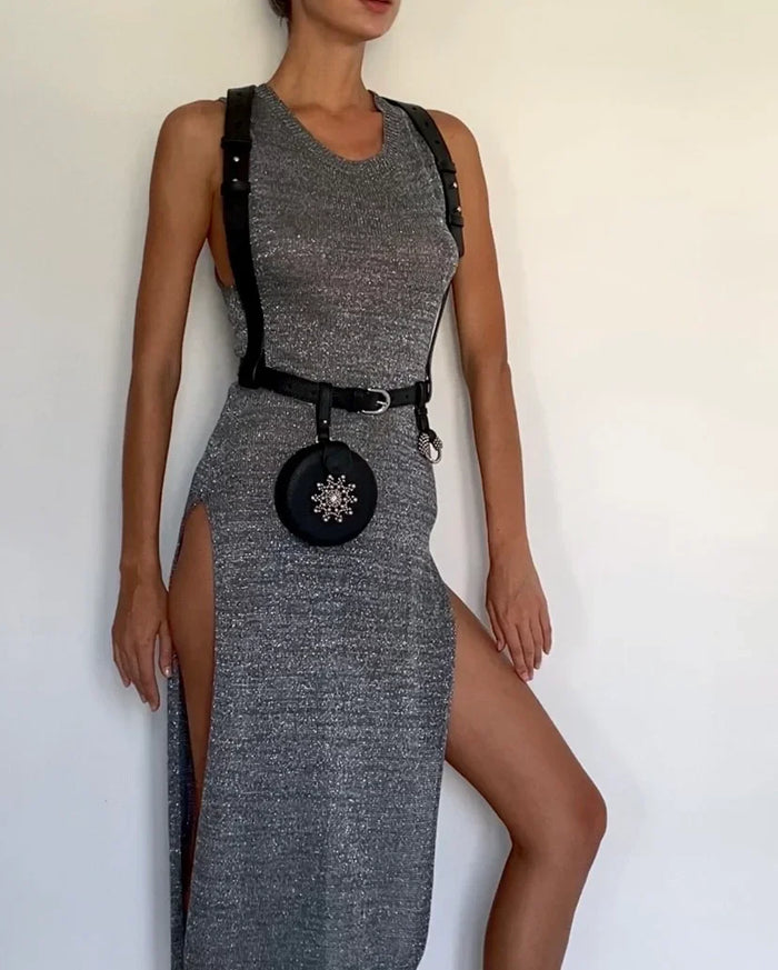woman in grey dress wears Zheng leather harness with beaded coin back by object & dawn in white background